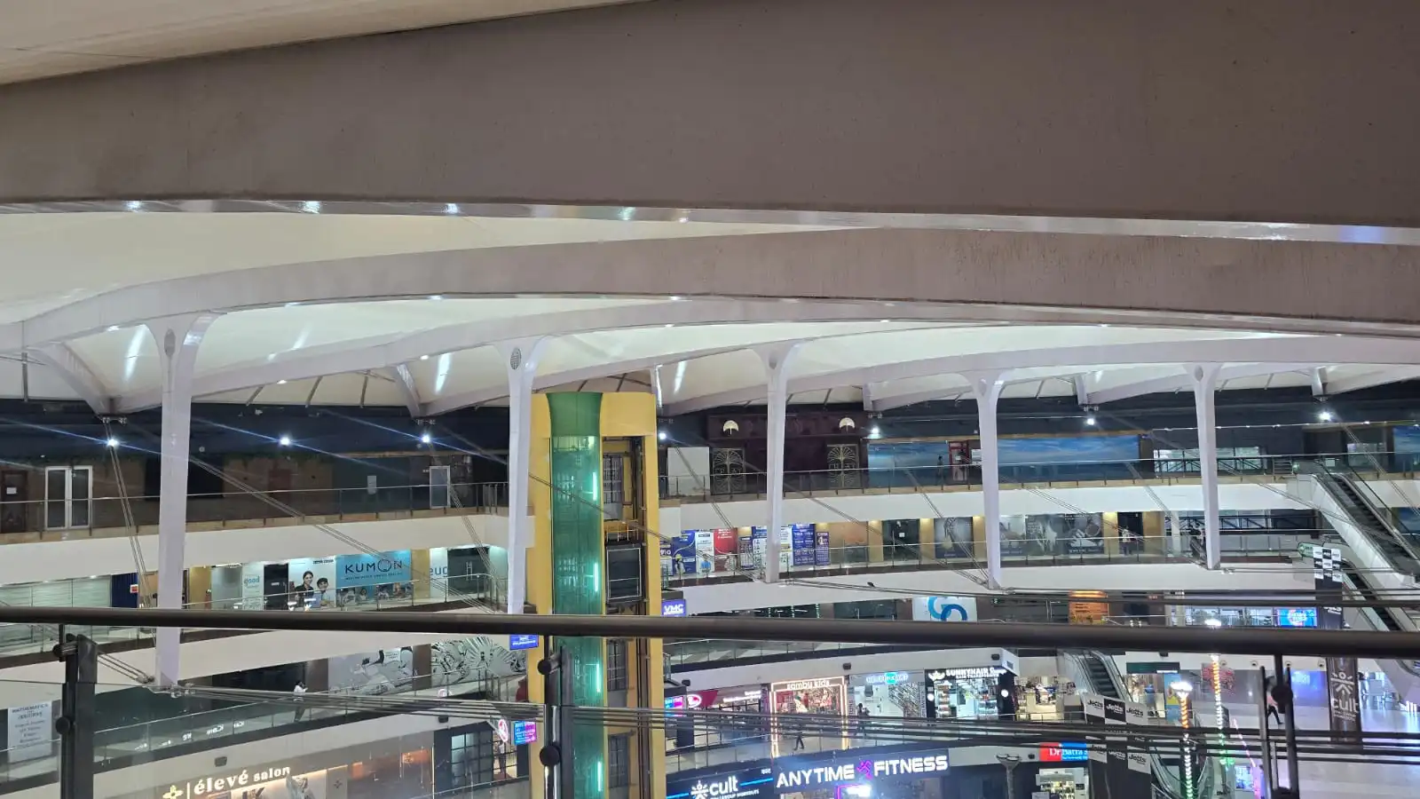 Vasant Square Mall Vasant Kunj — cable stays running from a steel mast head down to the membrane edge over the escalator court, Ekra Decor